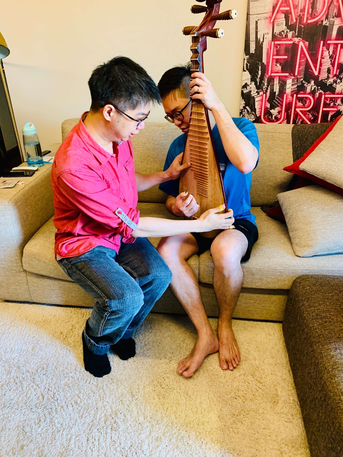 Pipa teacher Nicholas Ng guiding a student's posture during a home pipa lesson in Singapore